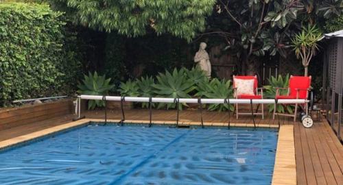 Swimming pool area with large trees that make it appear smaller and darker. With an ivy wall this all creates a lot of leaf litter.